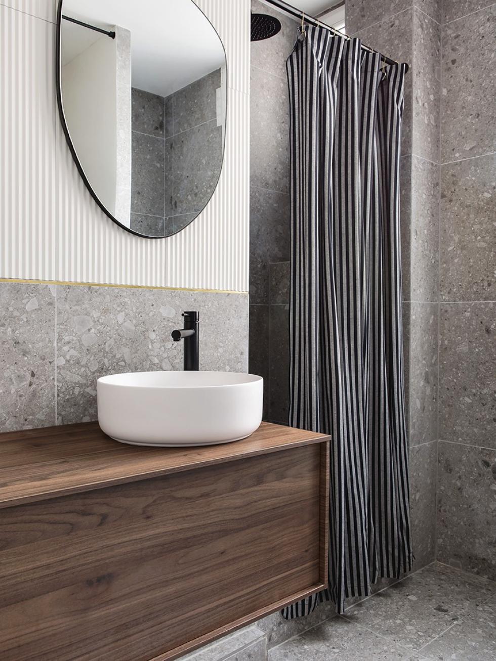 Meuble de salle de bain suspendu en noyer avec carrelage en terrazzo