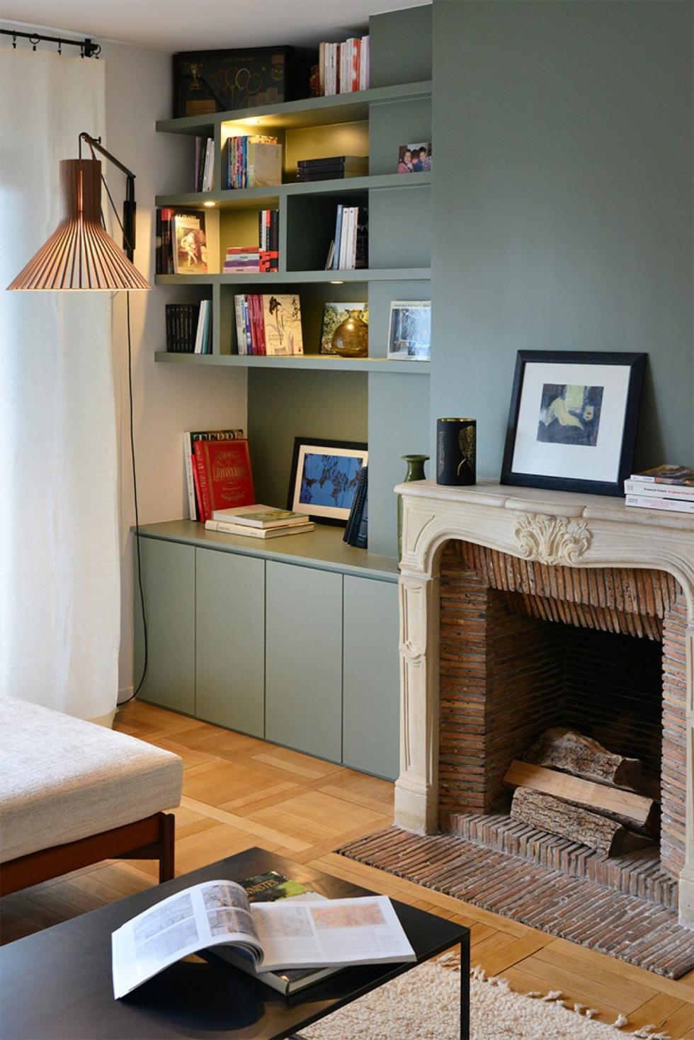 Salon avec cheminée entourée d'une bilbiothèque